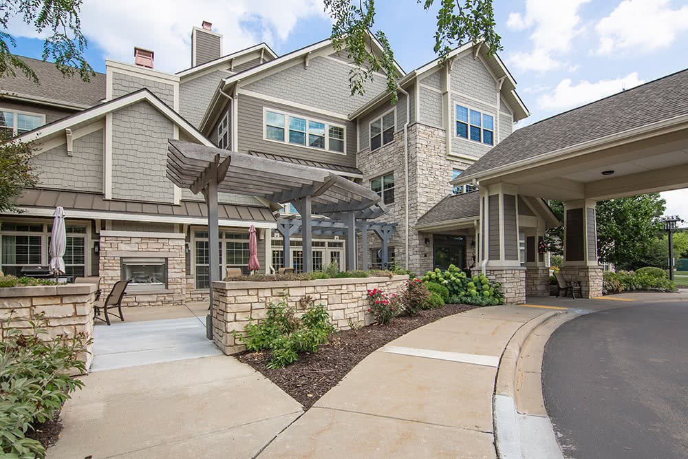 A modern residential building with well-maintained landscaping and a spacious driveway leading to the entrance.