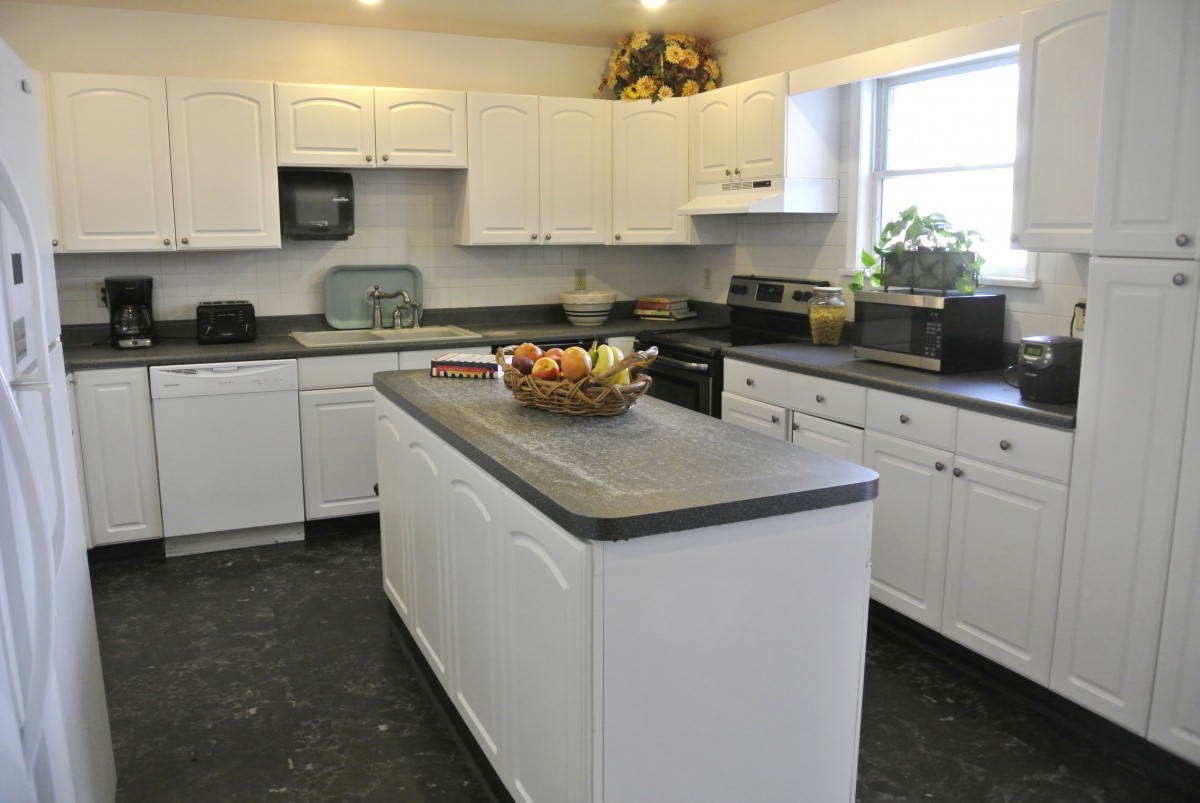 A modern kitchen with white cabinets and a central island.