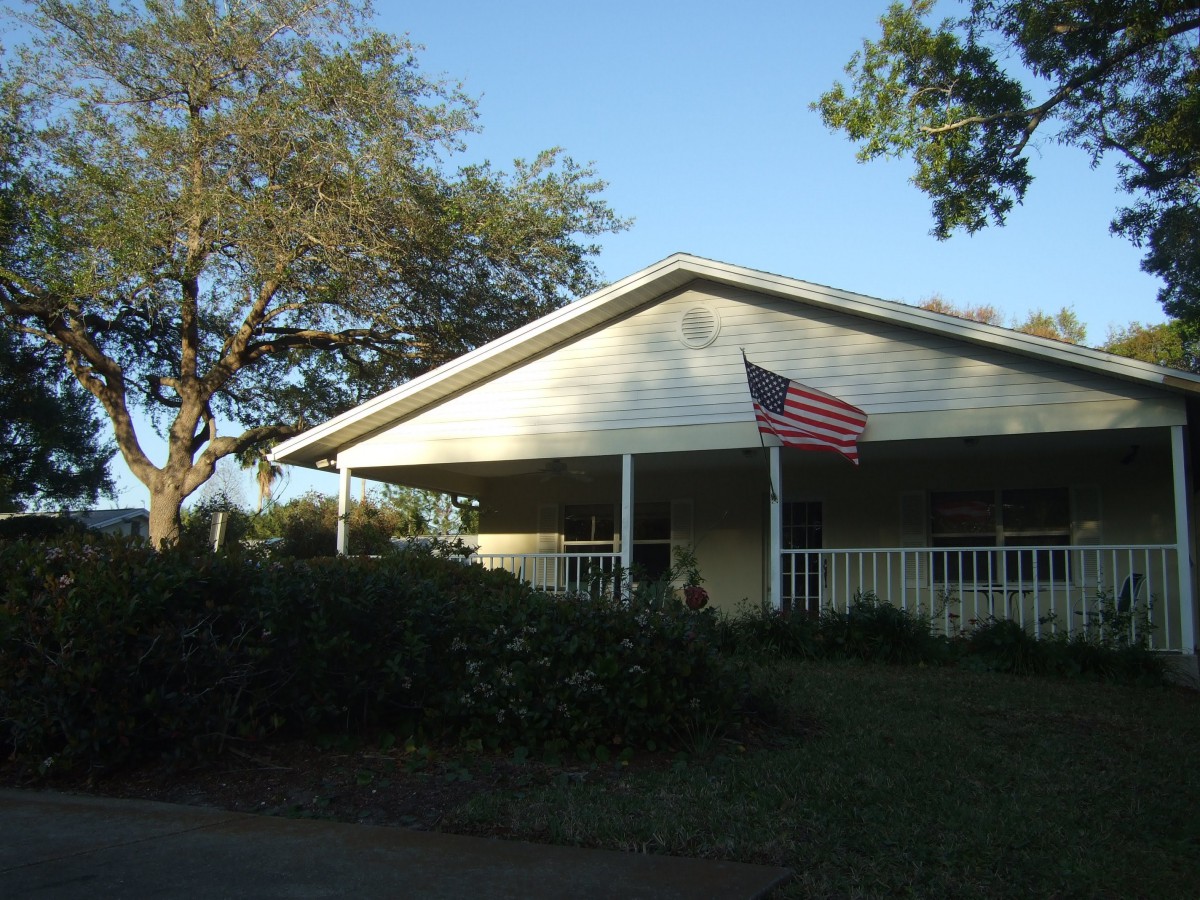 A suburban house with a porch and an American flag.
