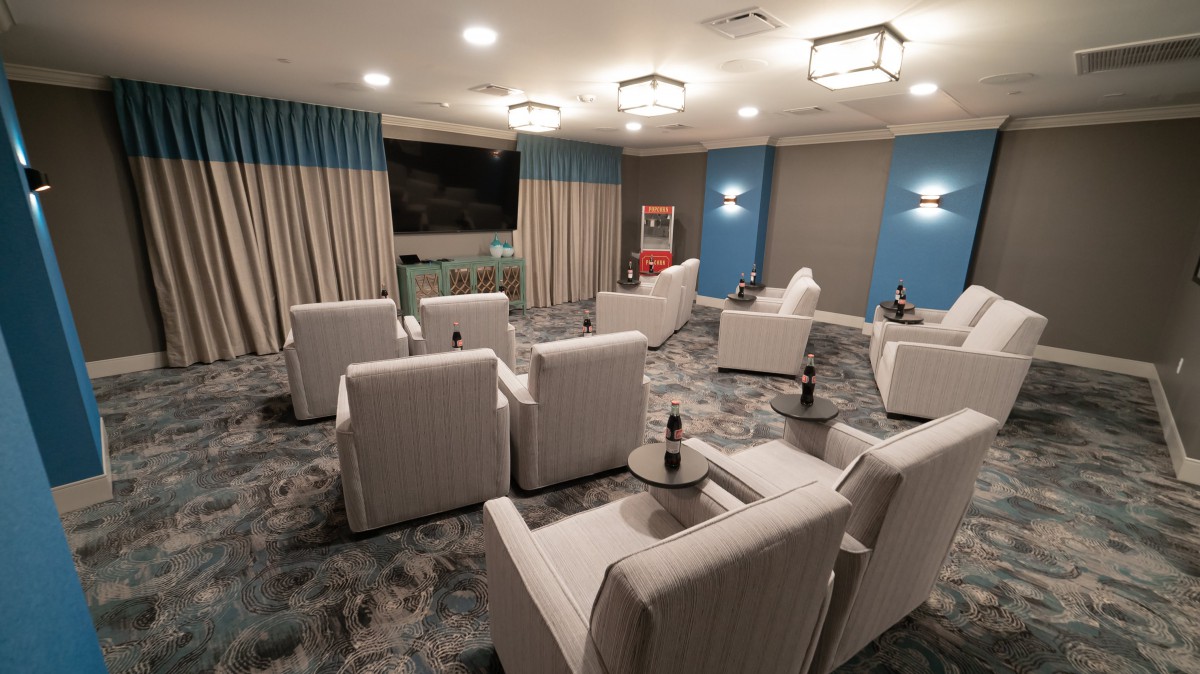 A modern home theater room with comfortable seating and a large screen.