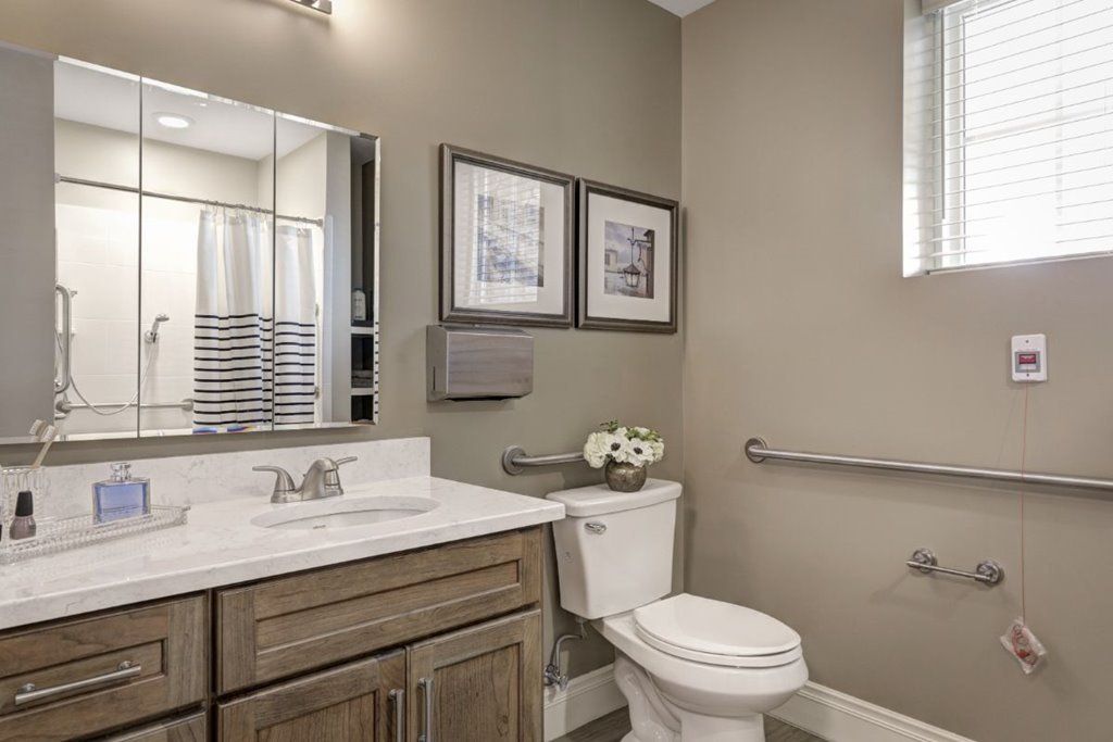 A neatly designed bathroom with neutral tones, featuring a toilet, sink, and decorative elements.