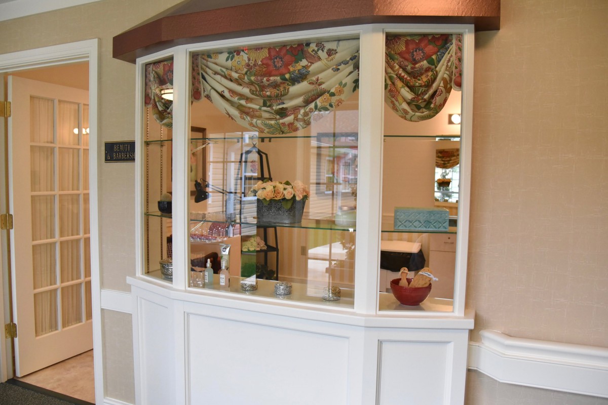 An interior view of a reception area with a window display featuring decorative items.