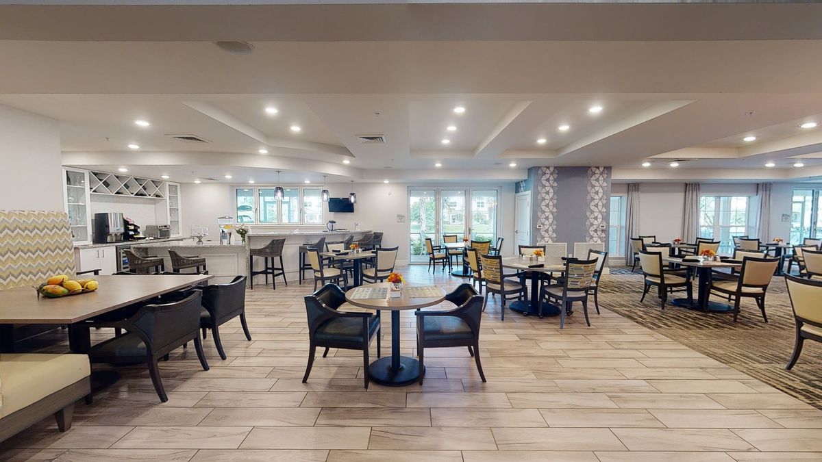 A modern and spacious restaurant interior with neatly arranged tables and chairs.