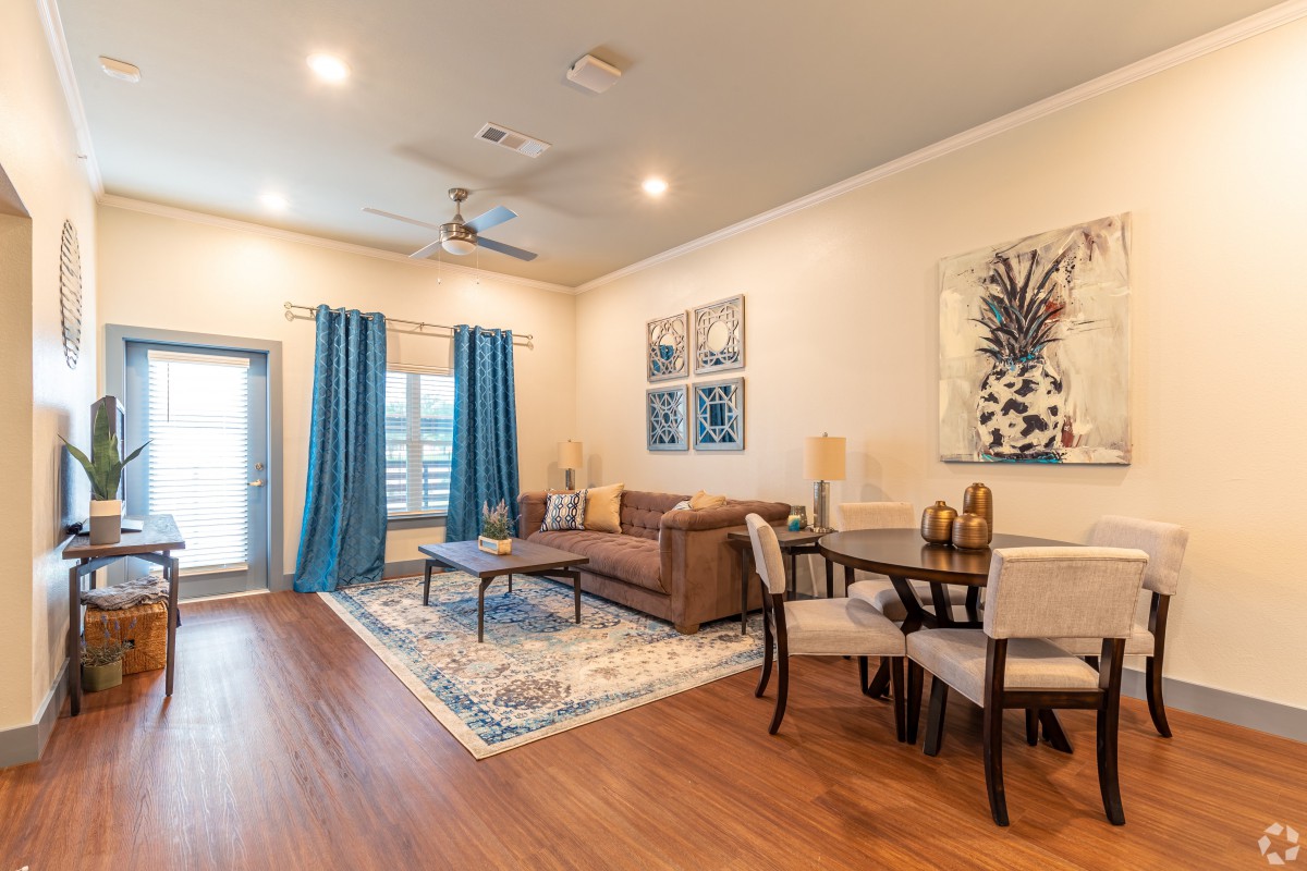 A modern living and dining area with stylish decor, featuring a comfortable sofa, dining table, and wall art.