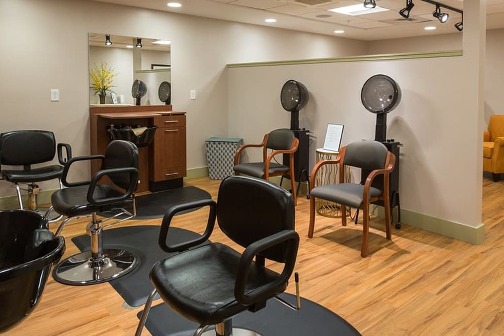 A modern hair salon interior with styling chairs and hair dryers.