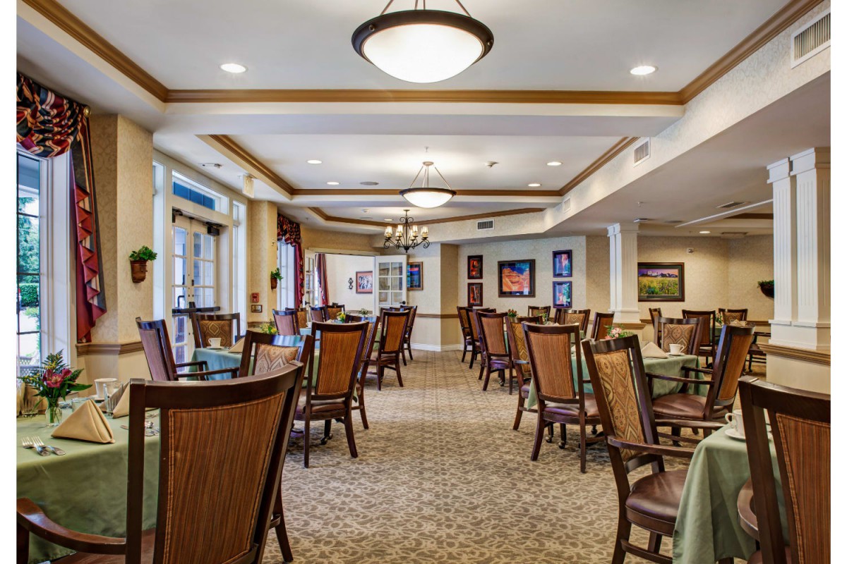 A well-lit dining area with arranged tables and chairs, featuring elegant interior design.