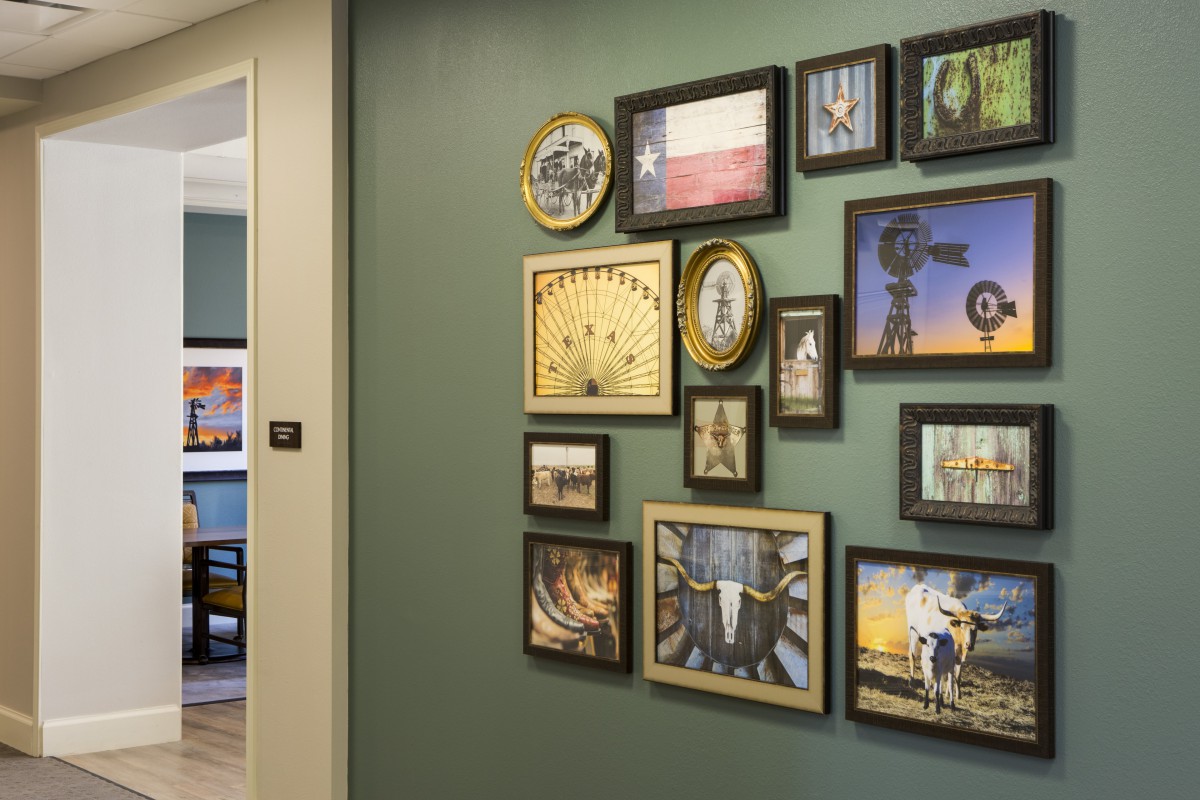 A creatively arranged photo wall in a hallway, featuring various artwork and frames.