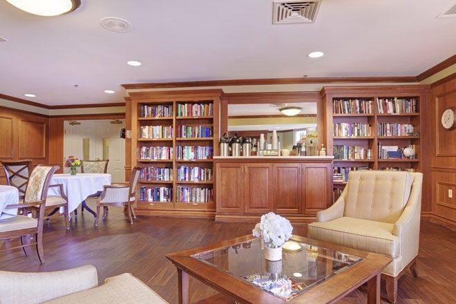 A cozy library with wooden bookshelves and comfortable seating.