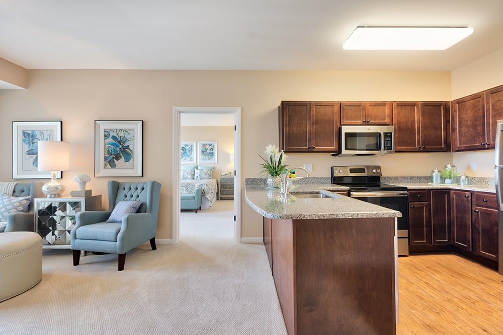 A modern open-plan kitchen and living area with wooden cabinets and comfortable seating.