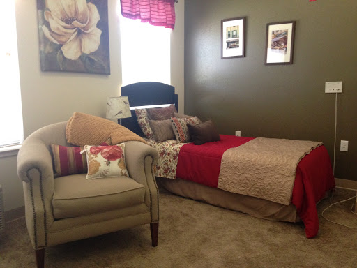 A cozy bedroom featuring a comfortable bed and a stylish armchair, complemented by decorative wall art.