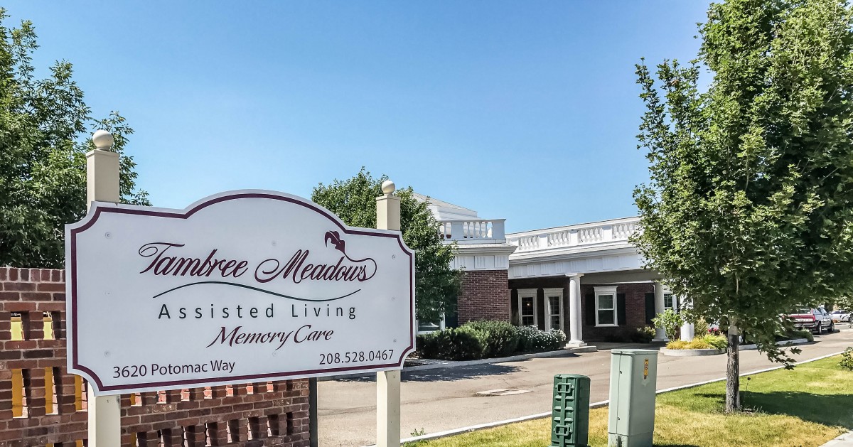 Entrance of an assisted living and memory care facility with a sign out front.