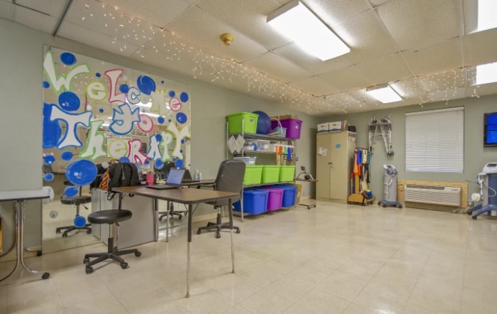 A classroom with colorful storage bins and tables.