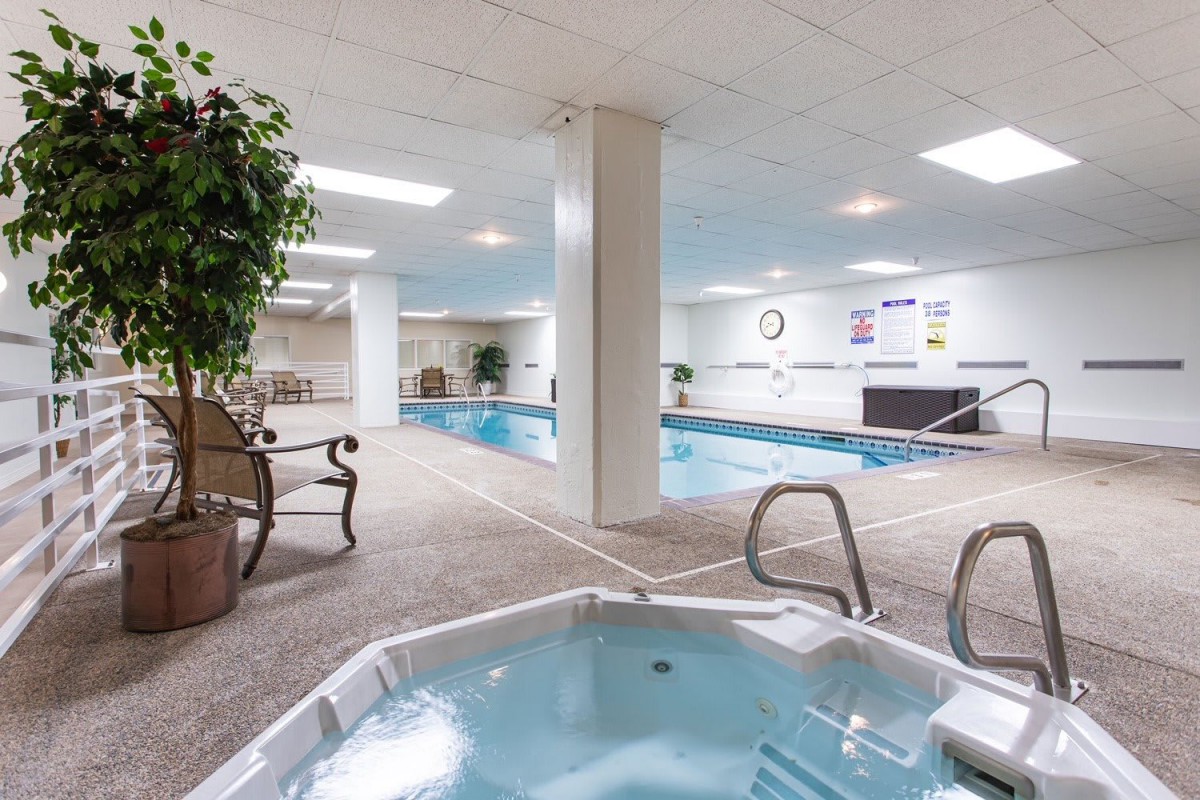 An indoor recreation area featuring a swimming pool and a hot tub for relaxation.