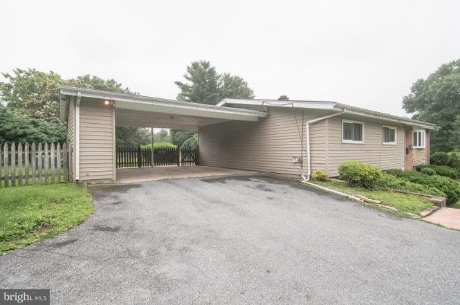 A single-story house with a carport and driveway in a suburban area.