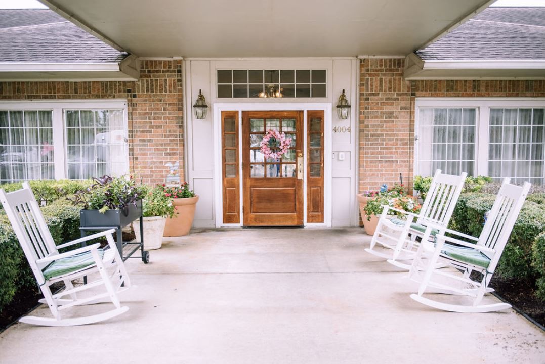 A welcoming front porch with rocking chairs and a decorated door.