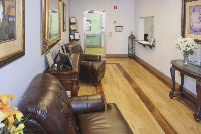 A cozy waiting room with leather chairs and framed artwork.