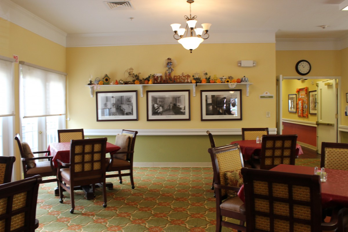 A cozy dining room with neatly arranged tables and chairs, featuring decorative wall art.