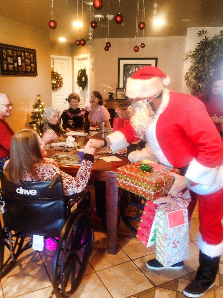 A festive family gathering with Santa Claus delivering gifts during a holiday celebration.