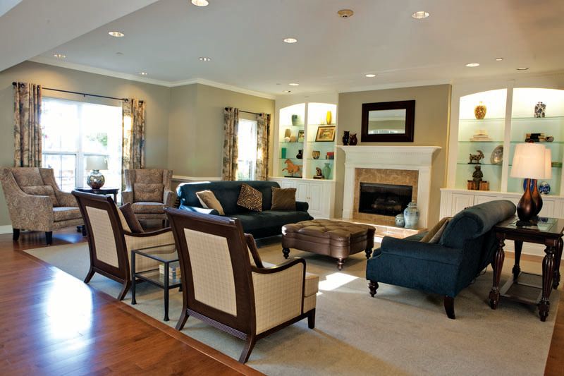 A spacious and elegantly designed living room featuring comfortable seating, a cozy fireplace, and tasteful decor.