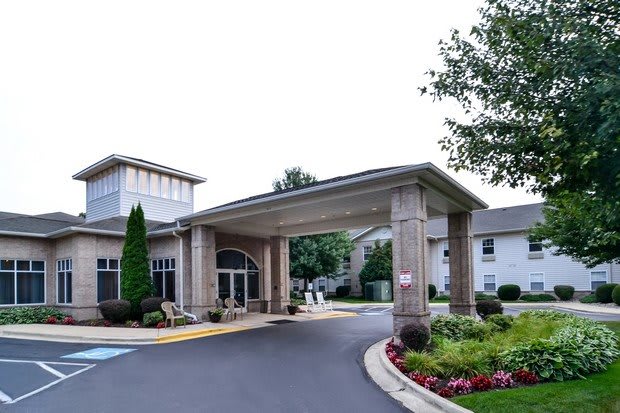 A modern building entrance with landscaping and flower beds.