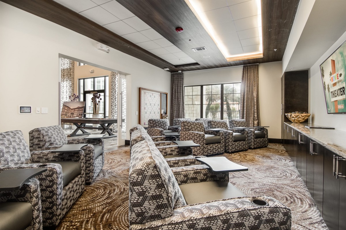 A modern lounge with patterned seating and large windows.