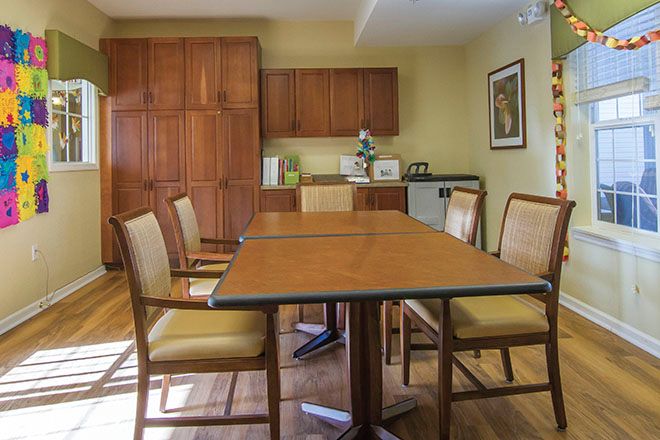 A cozy meeting room with a wooden conference table and chairs, set in an elegant office interior.