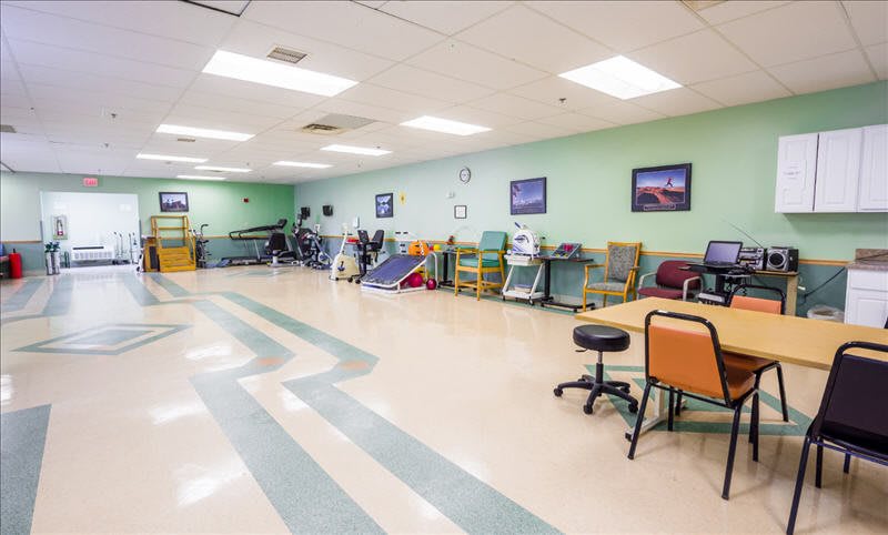 A spacious rehabilitation and physical therapy clinic with exercise equipment and seating.
