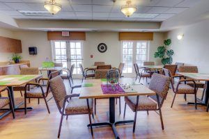 A well-lit dining area with neatly arranged tables and chairs, suitable for a restaurant or cafeteria setting.