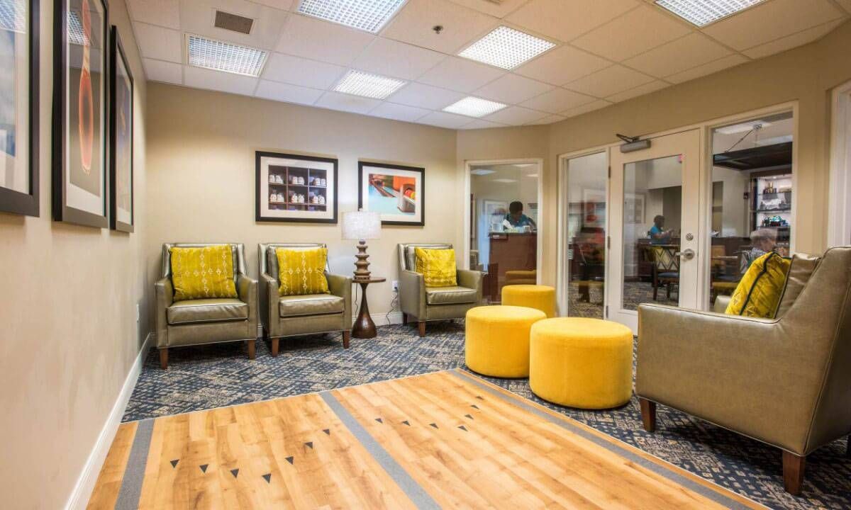 A modern waiting area featuring comfortable chairs and bright yellow accents.