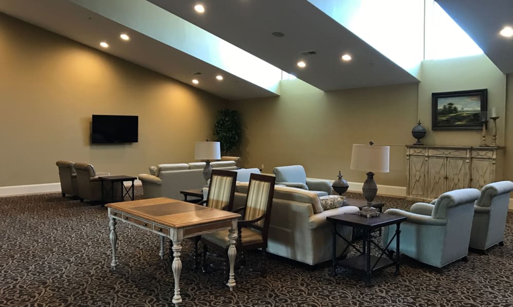 A modern living room with skylights, featuring comfortable sofas, tables, and stylish lighting.