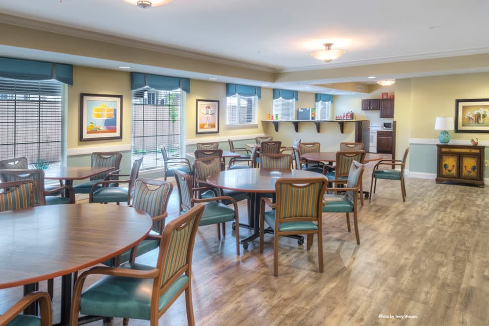 A spacious community room with tables and chairs arranged for gatherings.