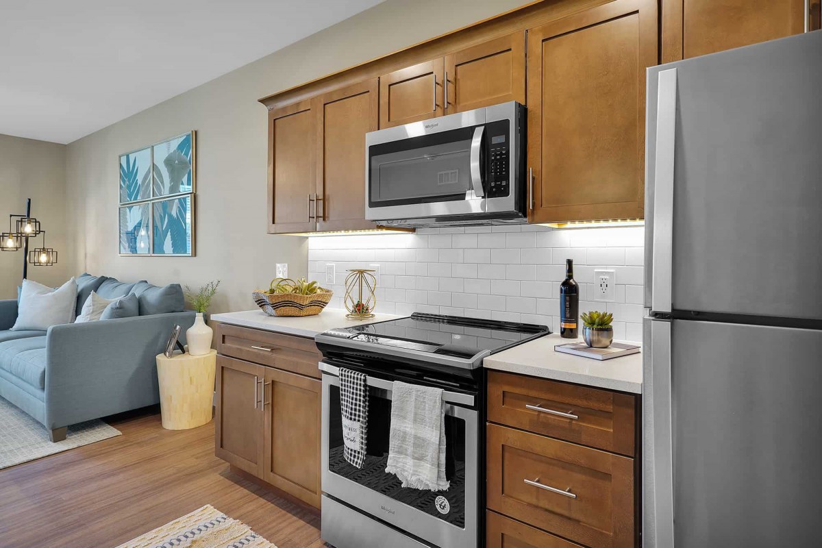 A modern kitchen with stainless steel appliances and wood cabinets.