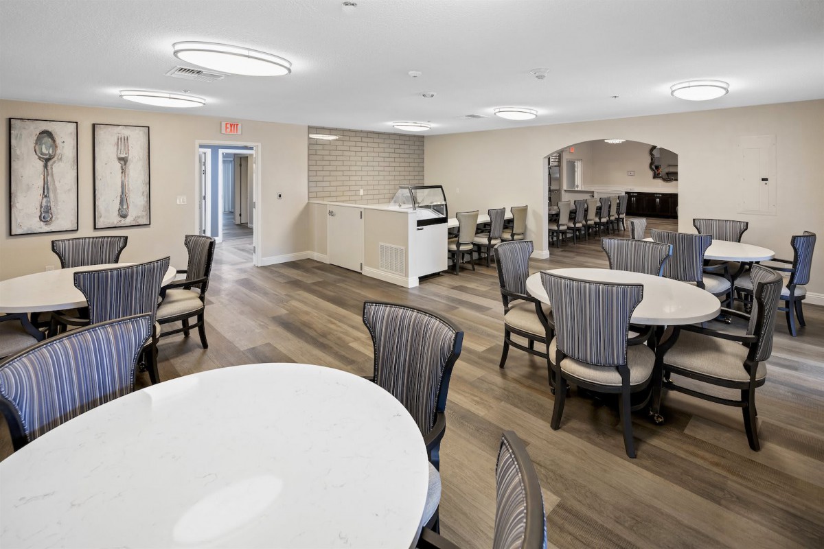 A modern dining area with round tables and stylish chairs, featuring elegant lighting fixtures.
