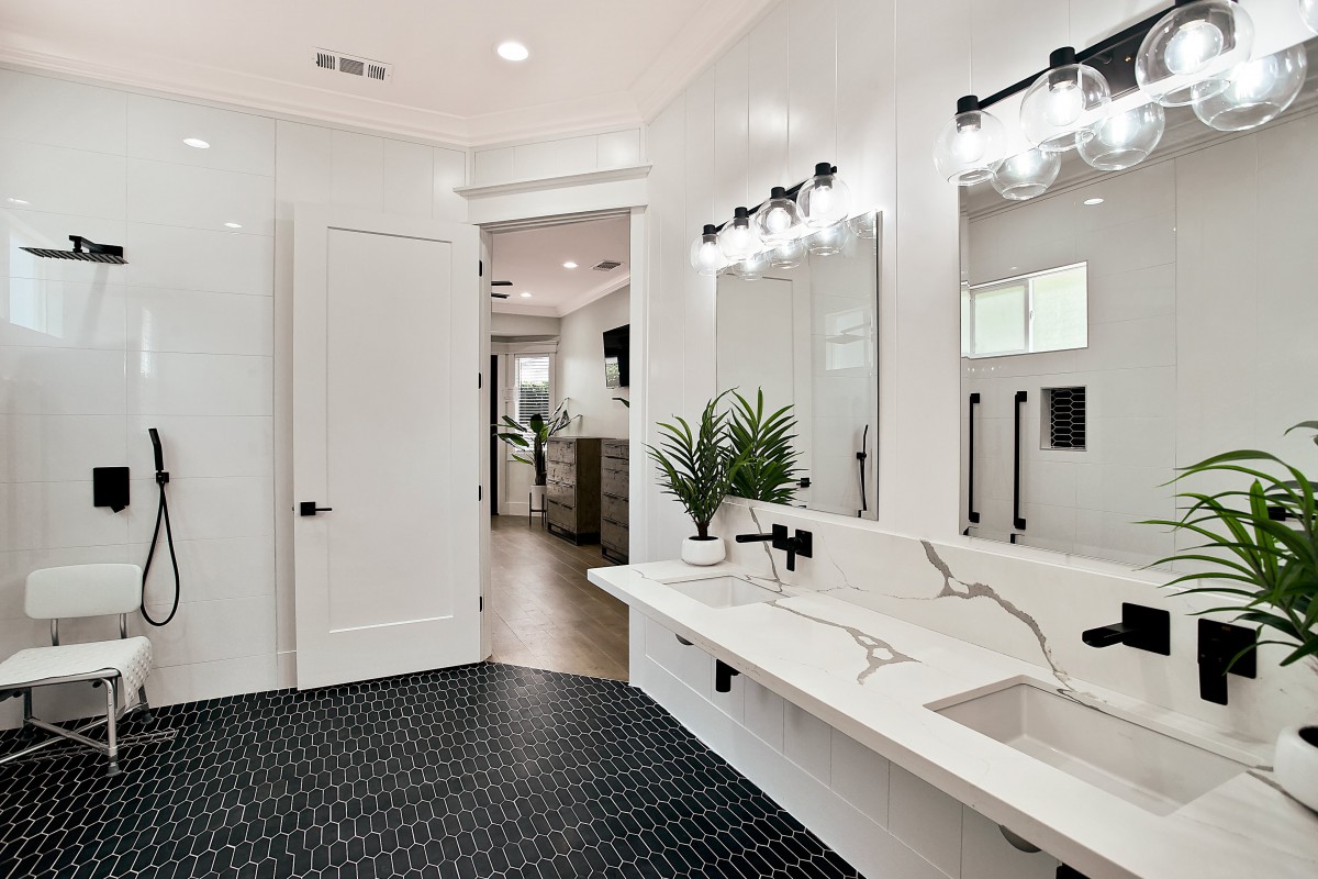 A modern bathroom with sleek fixtures, a large mirror, and minimalist decor.