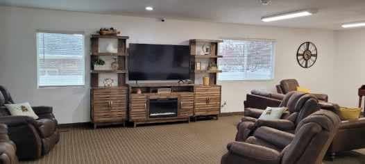 A cozy living room featuring a large entertainment center with a television and shelves.