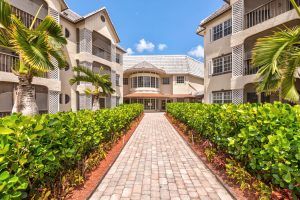 A pathway leading to a residential building surrounded by greenery.