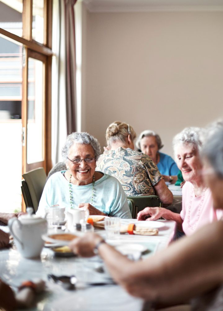 A group of seniors enjoying a meal together in a communal setting.