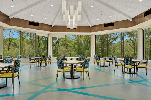 A bright and modern dining area featuring large windows that offer a view of the surrounding nature.