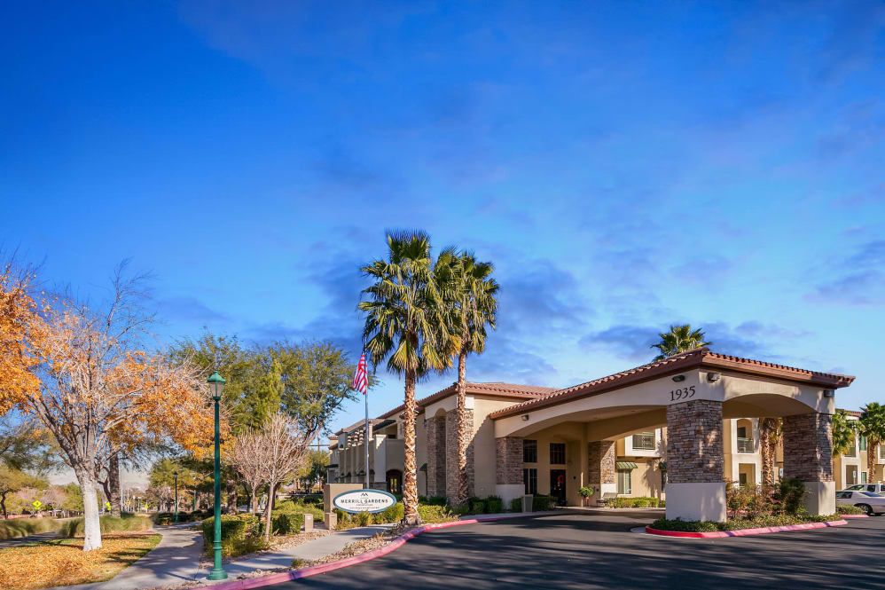 A sunny view of a hotel entrance with surrounding palm trees.