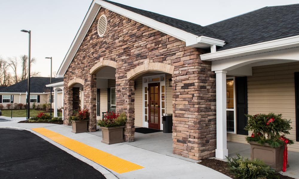 A brick facade building with a welcoming entrance and landscaped surroundings.