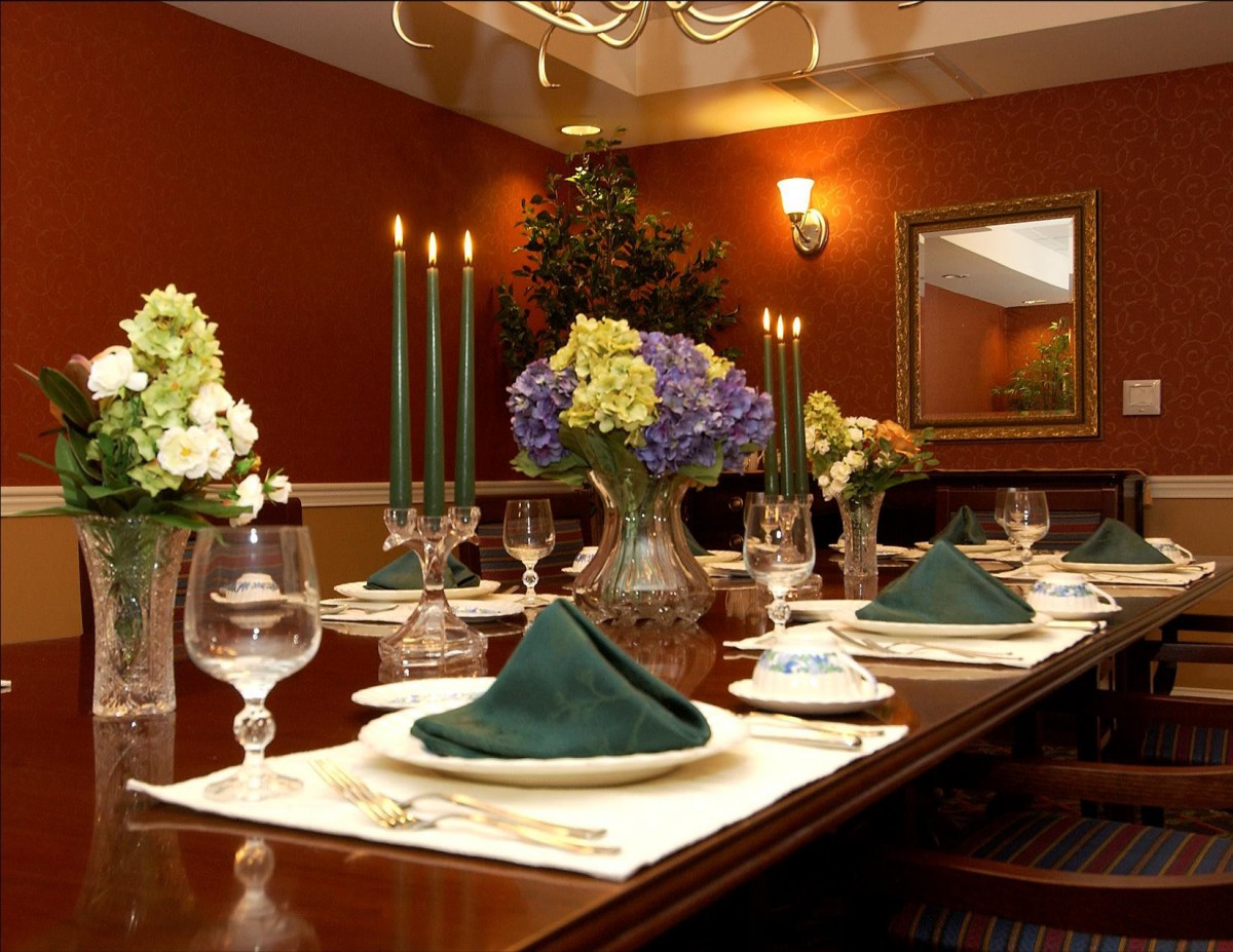 An elegantly set dining table with candles and floral arrangements.