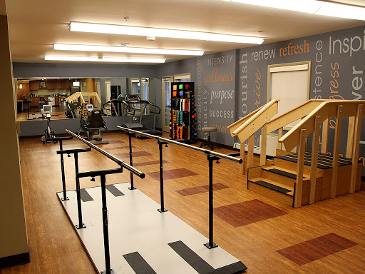 A physical therapy room equipped with parallel bars and stairs for rehabilitation exercises.