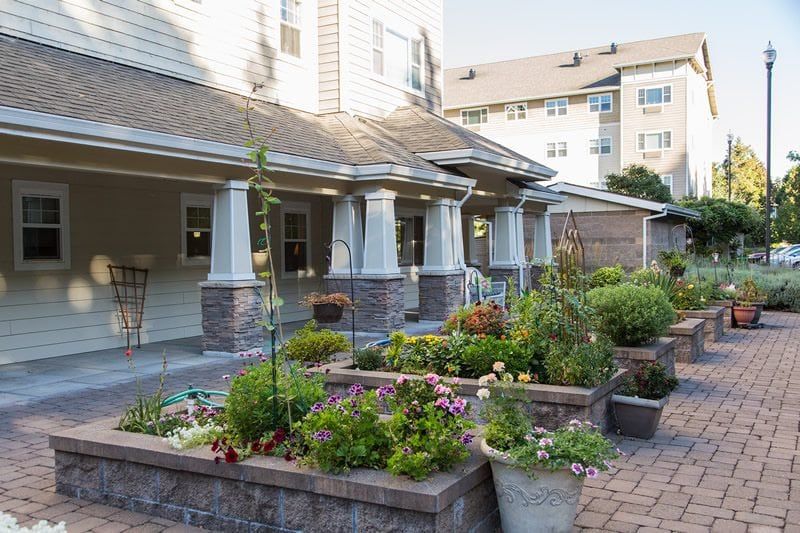 A well-maintained garden with vibrant flowers in front of a residential building.