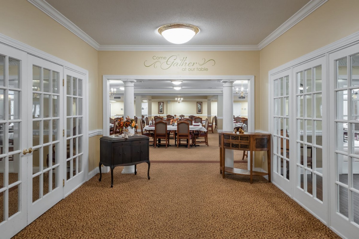 Elegant dining area with multiple tables and chairs, featuring warm lighting.