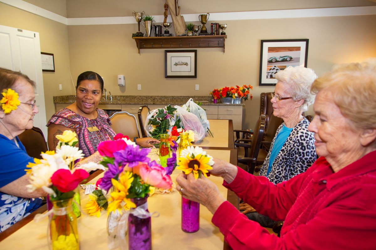 Seniors enjoying a flower arranging activity at a community center.