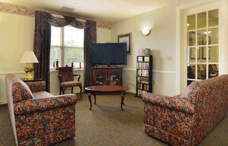 A cozy living room with patterned furniture and a flat-screen TV.