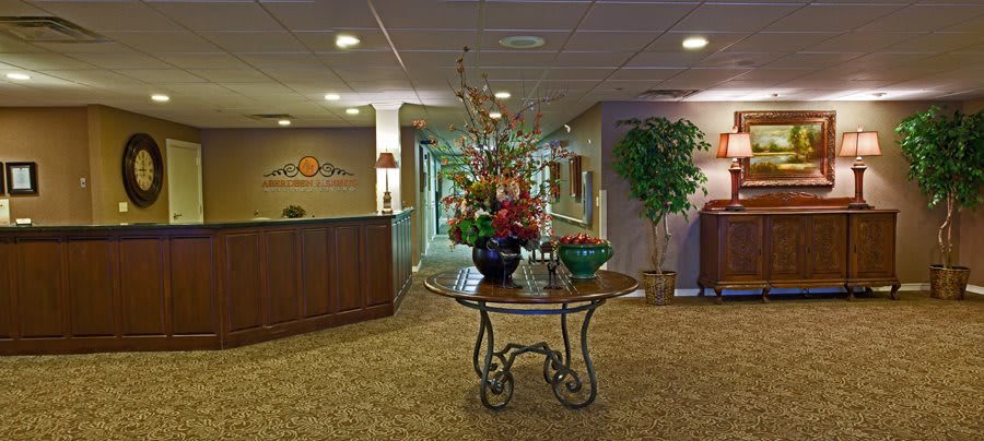 A welcoming lobby with a central table displaying a floral arrangement.