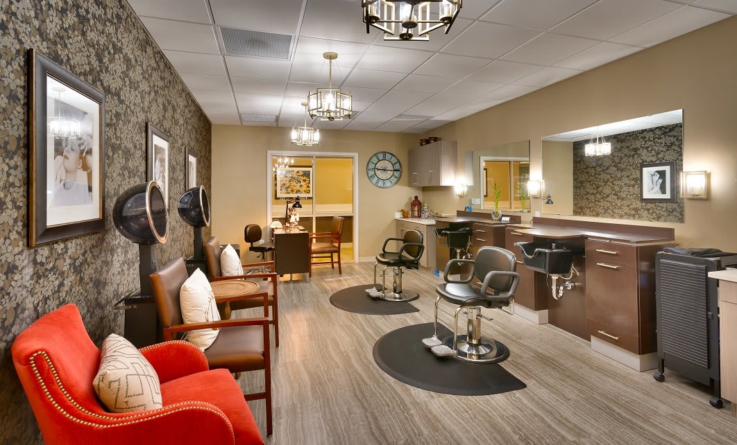 A modern salon interior with styling chairs, mirrors, and a waiting area.