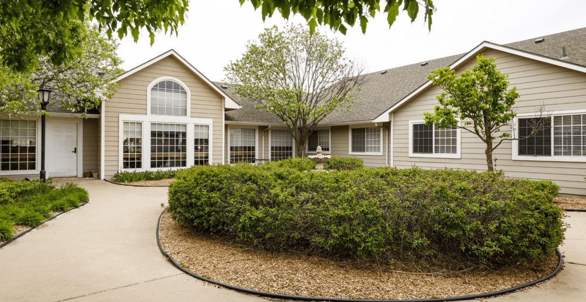 A well-maintained house with a lush garden and curved pathway.
