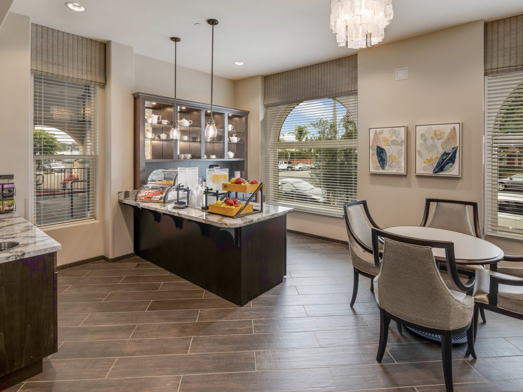 A modern kitchen and dining area with a central island, contemporary lighting, and elegant decor.